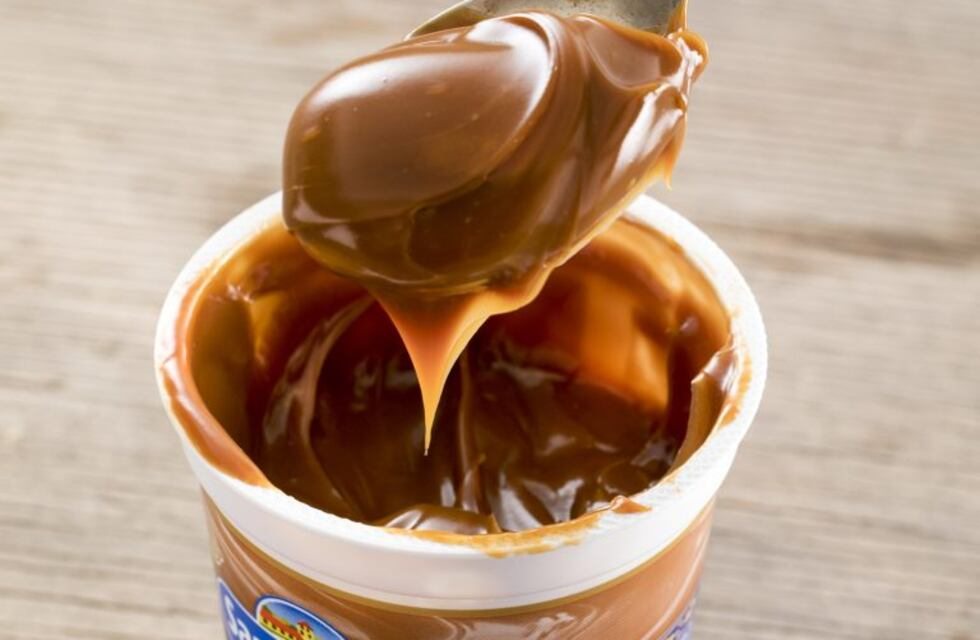 Spoonful of creamy Argentine dulce de leche taken from an open container — a rich caramel spread popular in South American desserts. Spoonful of creamy Argentine dulce de leche taken from an open container — a rich caramel spread popular in South American desserts.