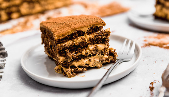 Porción de chocotorta argentina fácil con capas de galletitas y dulce de leche en plato blanco